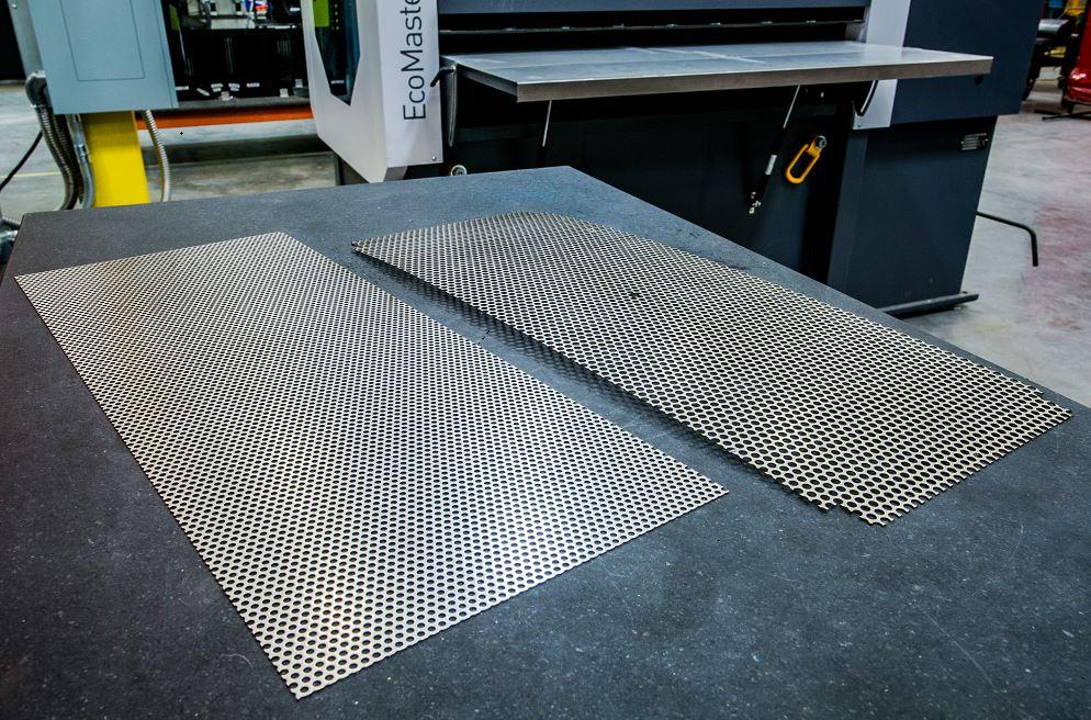 A level perforated sheet and a warped perforated sheet sit on a table.