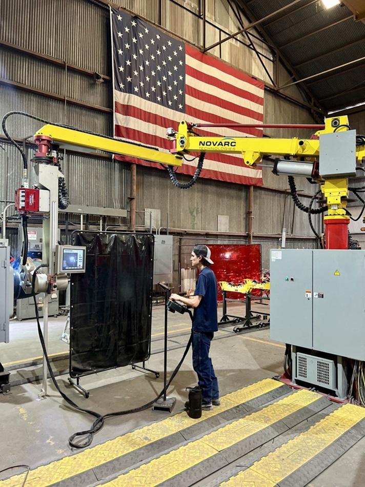 The operator programs the robotic welder.