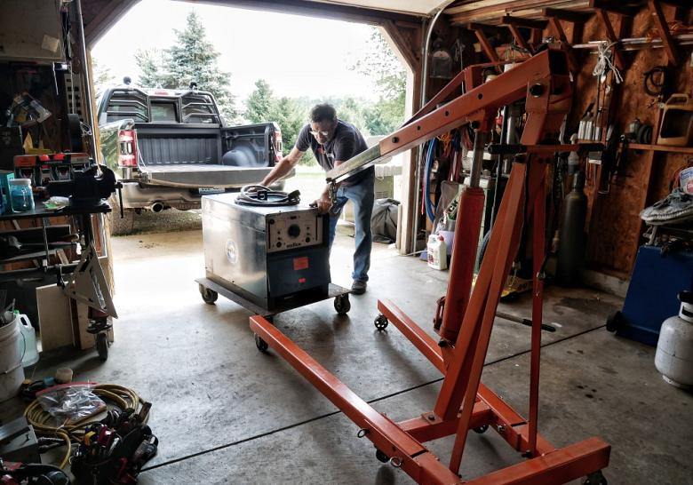 Josh Welton hauling old Miller welding equipment in his garage