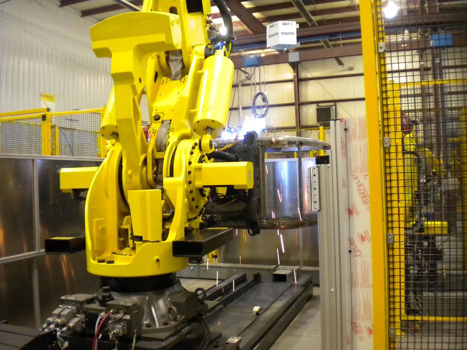 material handling robot positions the part for the welding robots