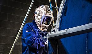 Soldador soldando con equipo de protección adecuado