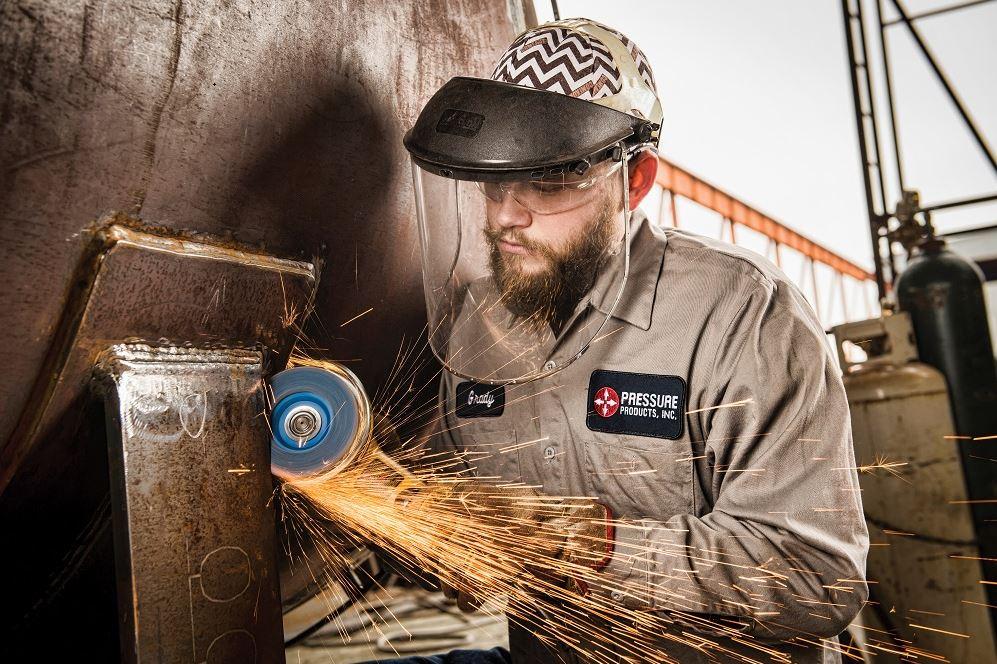 metal fabricator using an angle grinder 