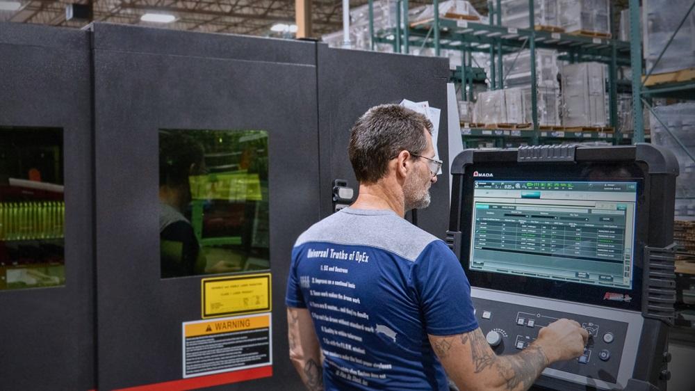 A technician programs a laser cutting machine.