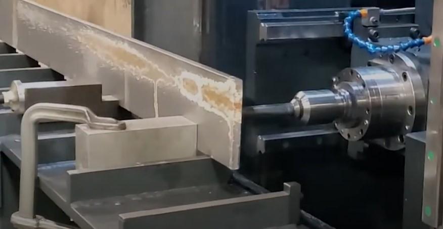 A drill engages a metal workpiece.