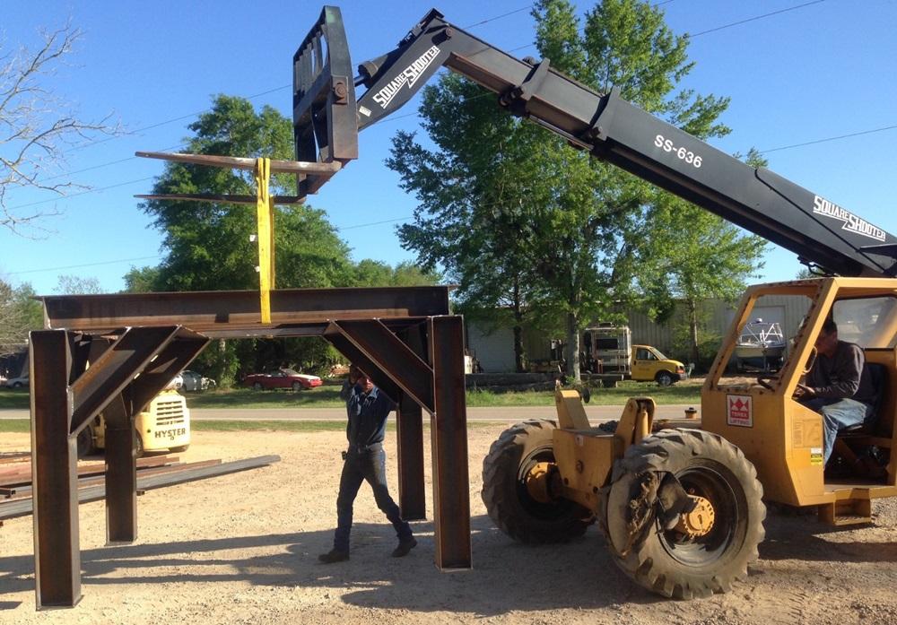 A structure made of steel beams is lowered to the ground.