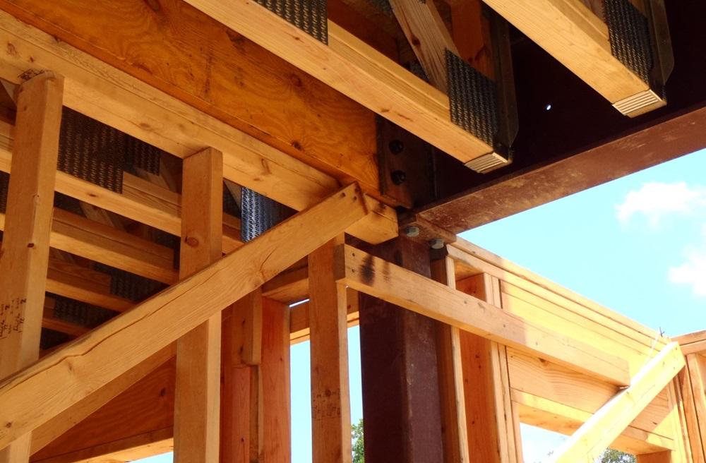 Structural steel beams and wood beams are shown as part of a home construction. 