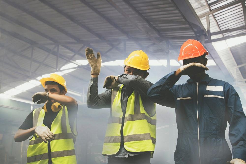 Workers cover their faces to avoid fumes.