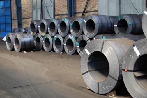 Steel coils sit in a warehouse.