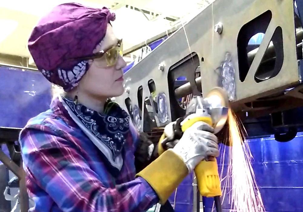 Metal fabricator uses a grinder