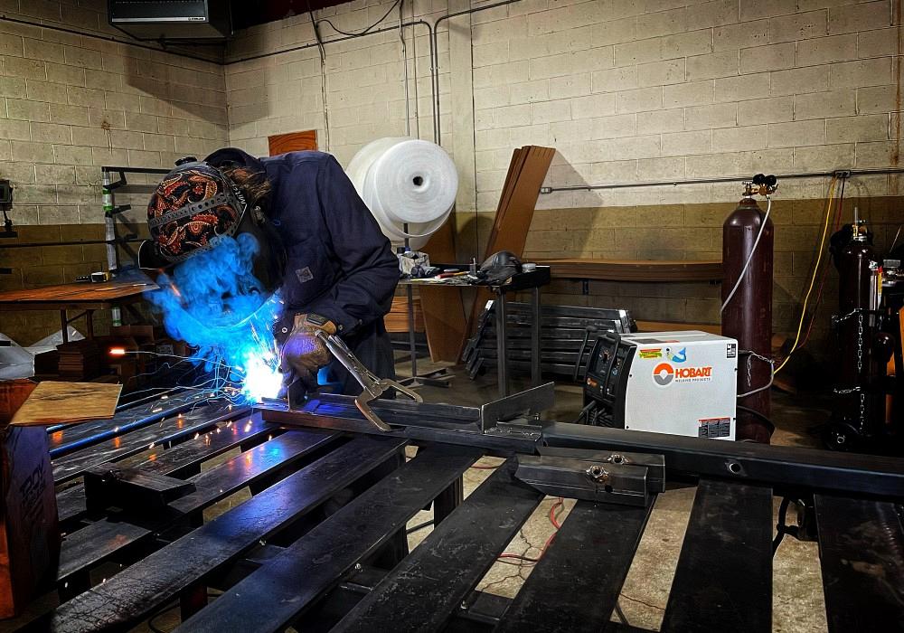 metalworker welding in his fabrication shop
