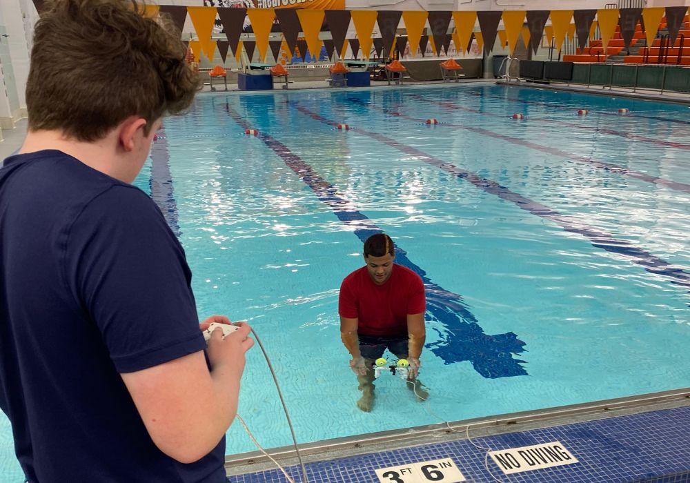 A student-fabricated submersible is launched in a middle school pool. 