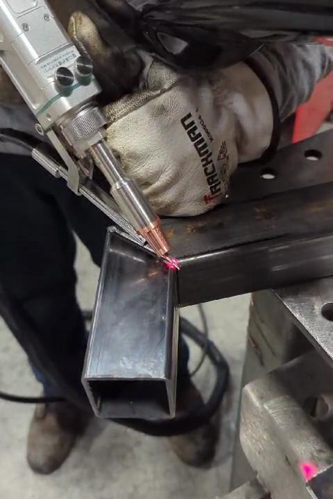 A person laser-welds a tube