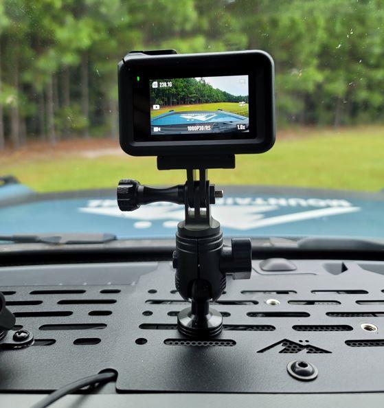 A small video camera is mounted to a dashboard.