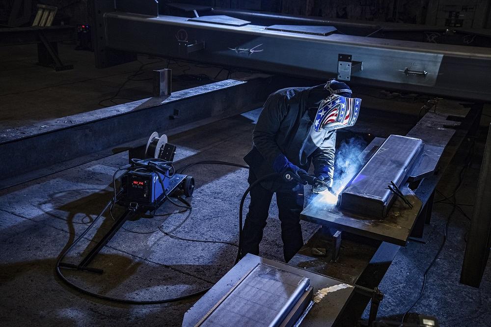 A welder on a construction site using shielded metal arc welding (SMAW)