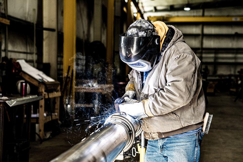 A welder works on a pipe.