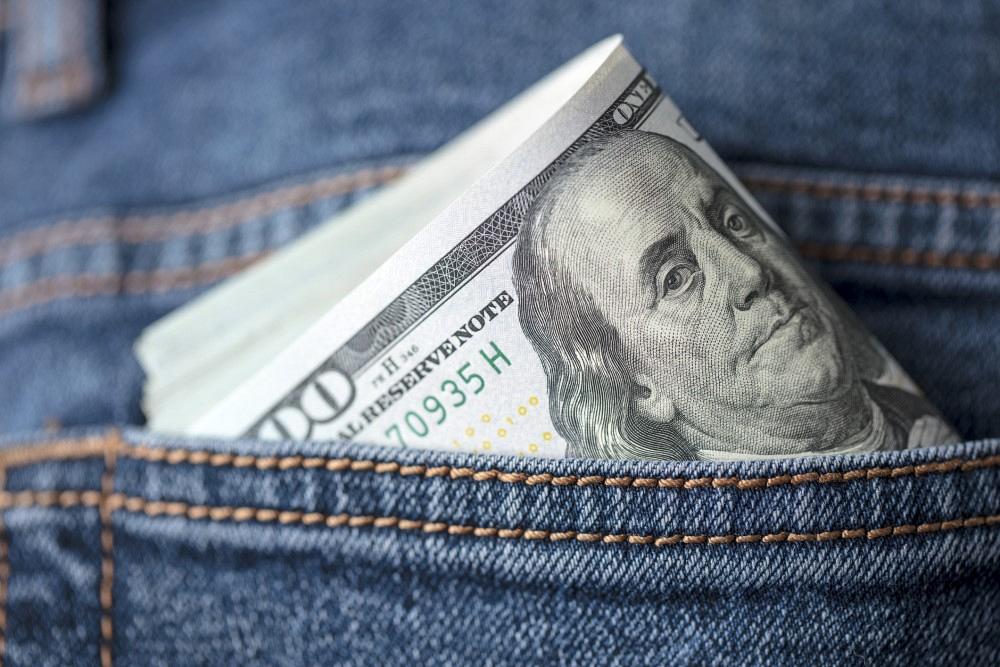 Close-up of US $100 dollar bills in jeans pocket