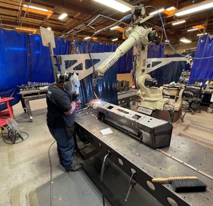 A technician programs a welding robot.