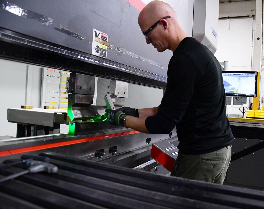 An operator forms a part on a press brake.
