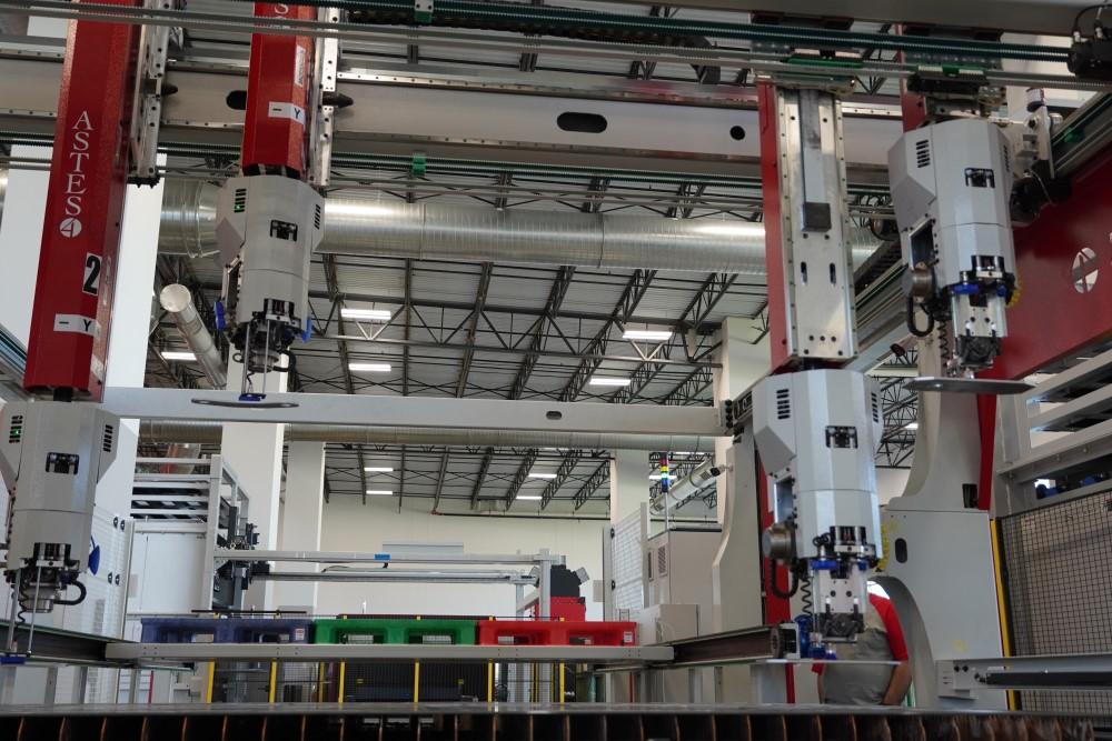 An automated parts sorting system removes laser-cut parts.