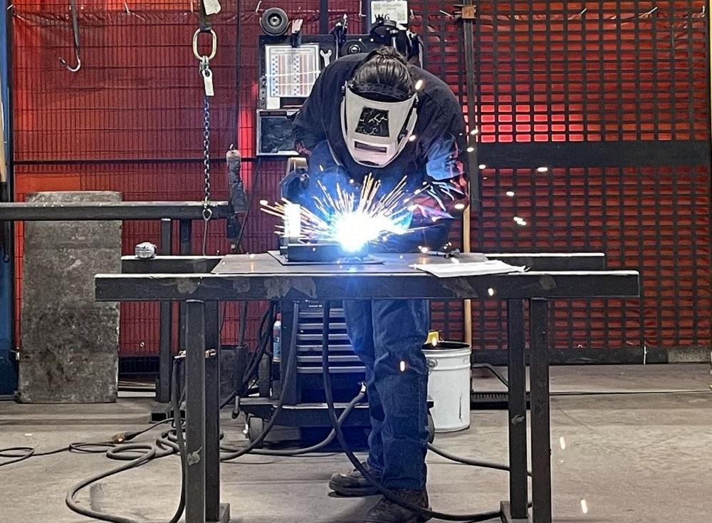 A welding student works on a project.