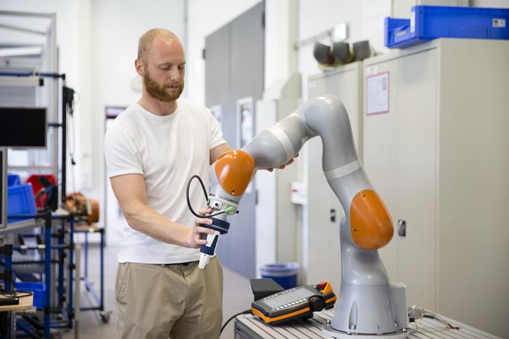 A technician works with a cobot.