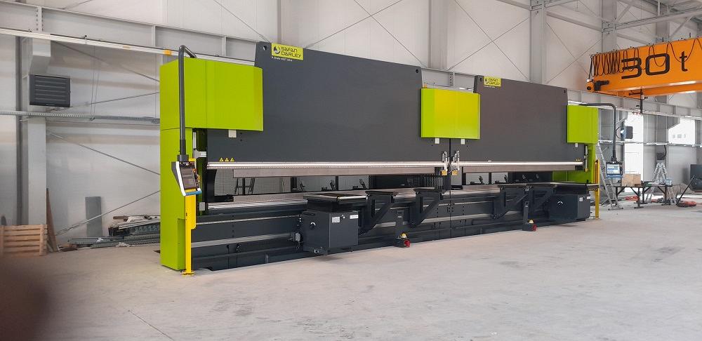 Una nueva prensa dobladora en tándem se instala en un taller de fabricación de metal.