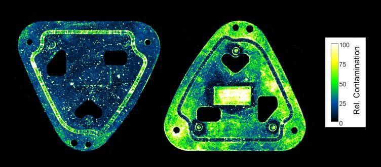 A scan shows two triangular metal parts with different contamination distributions.