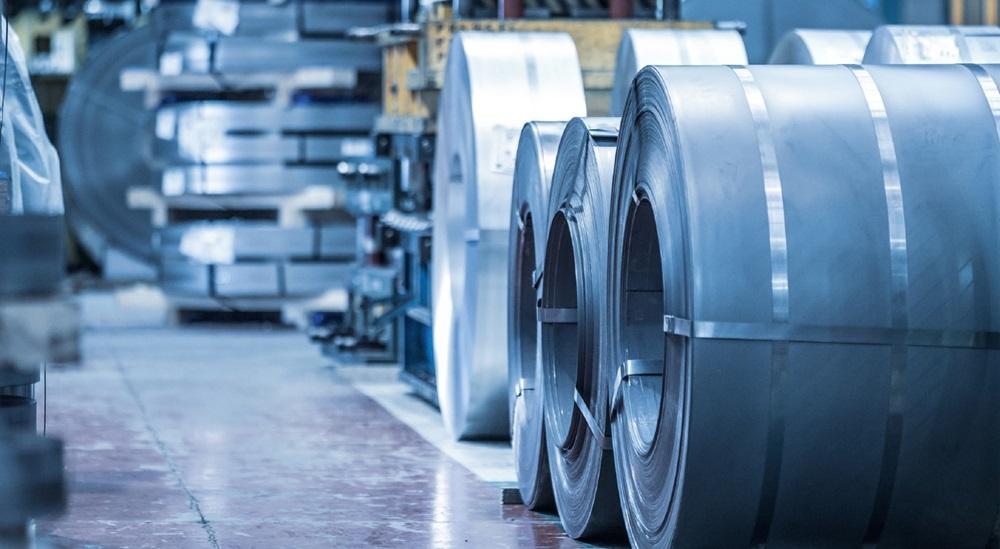 Coiled metal sits on a factory floor