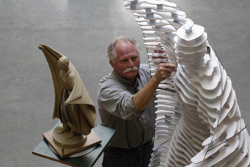 A man builds a replica statue.