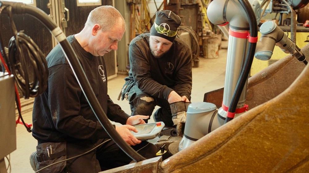 Two individuals use a cobot.