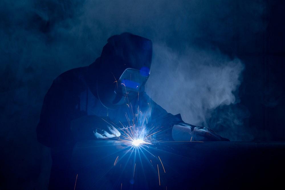 Professional welder and mask welding metal pipe at industrial. 