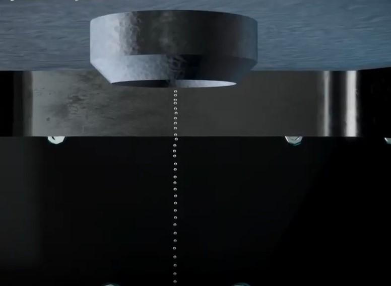 individual drops of molten metal exit the nozzle in 3d printing