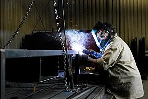 A welder works on a tube fabrication.
