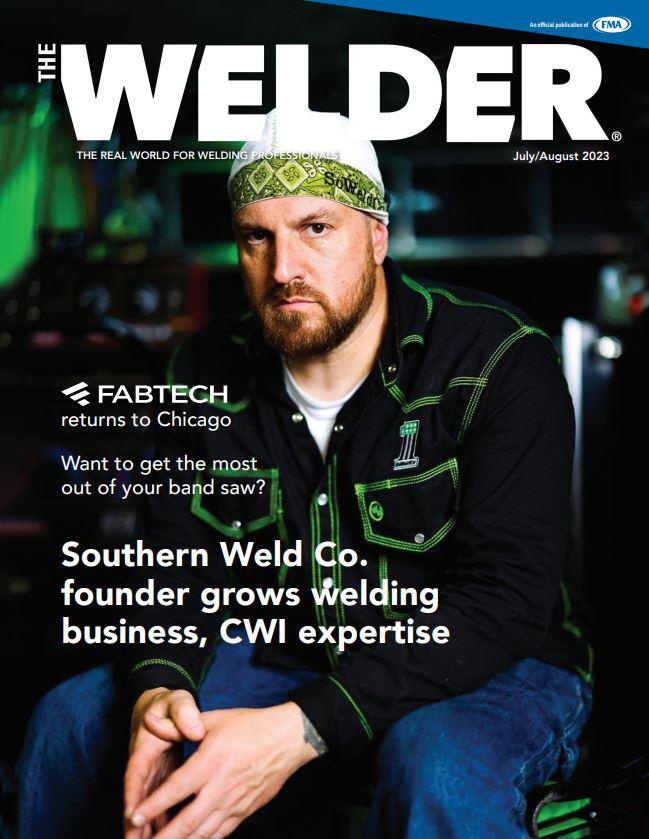 A male welder looks at the camera.